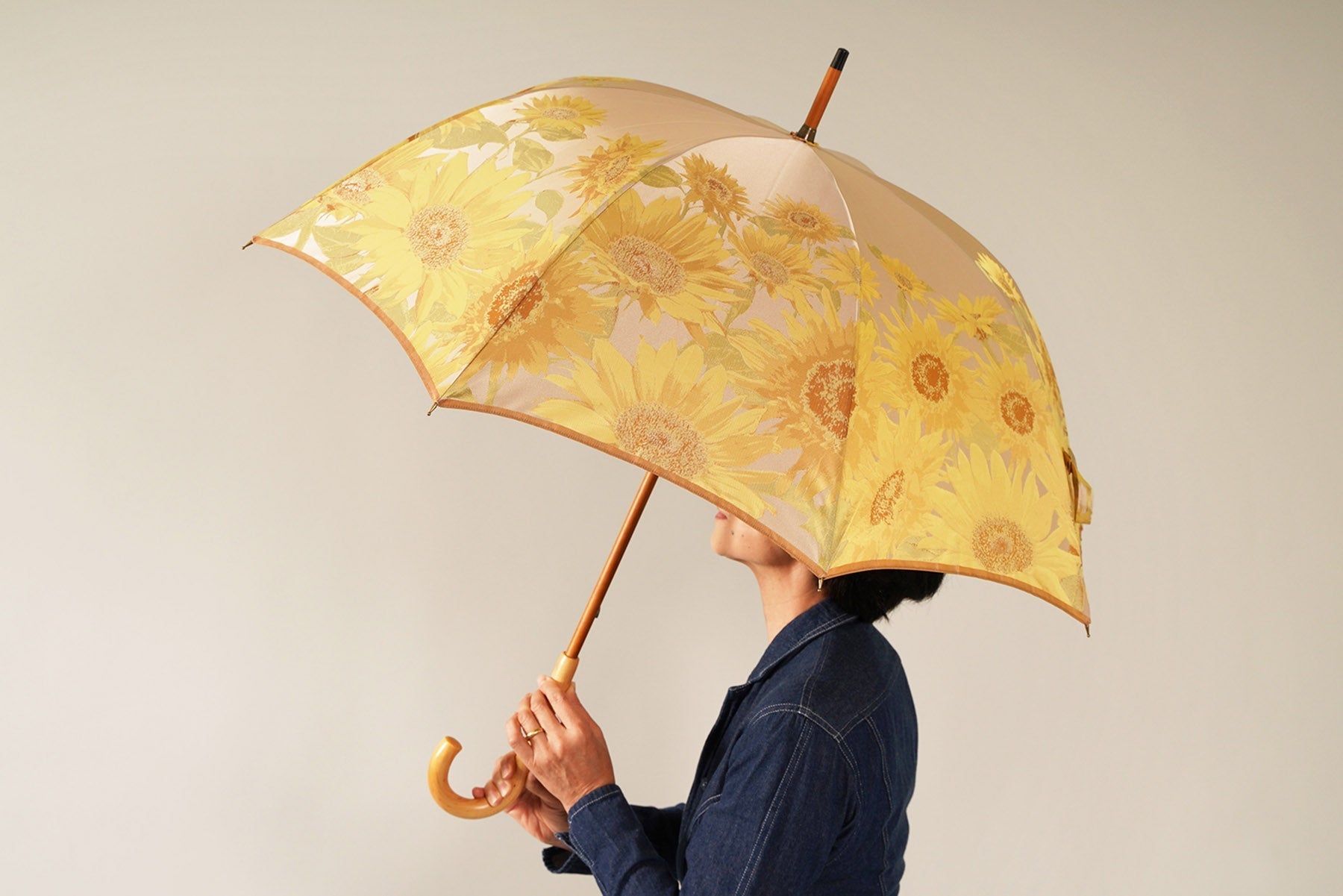 向日葵柄の傘を差す女性の画像