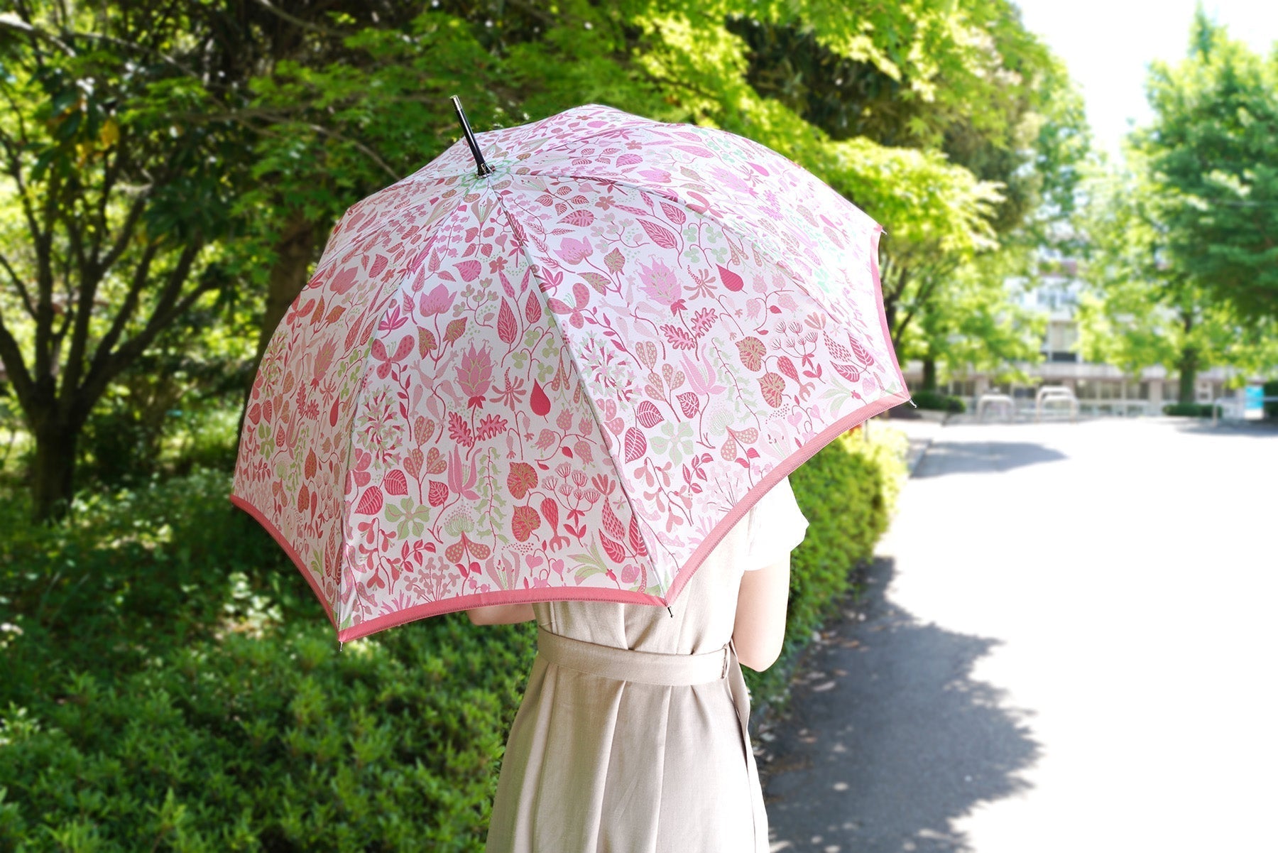 ピンクの植物柄の傘を差す女性の画像