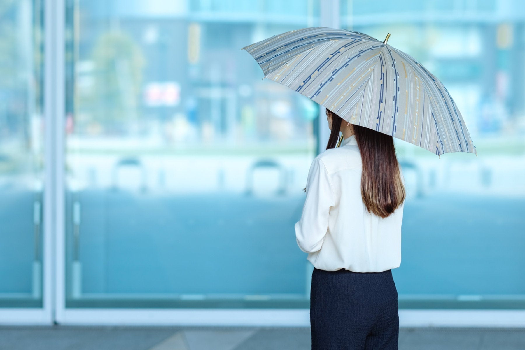 カーキ色の日傘を差す女性