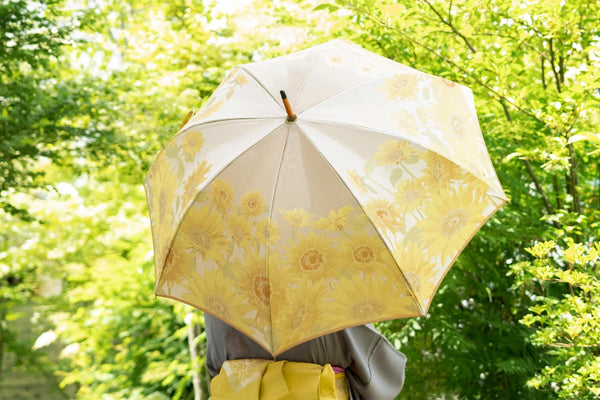 向日葵柄のレディース長傘を差す女性