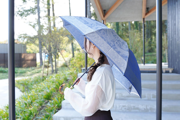 ブルーのペイズリー柄の傘を差す女性