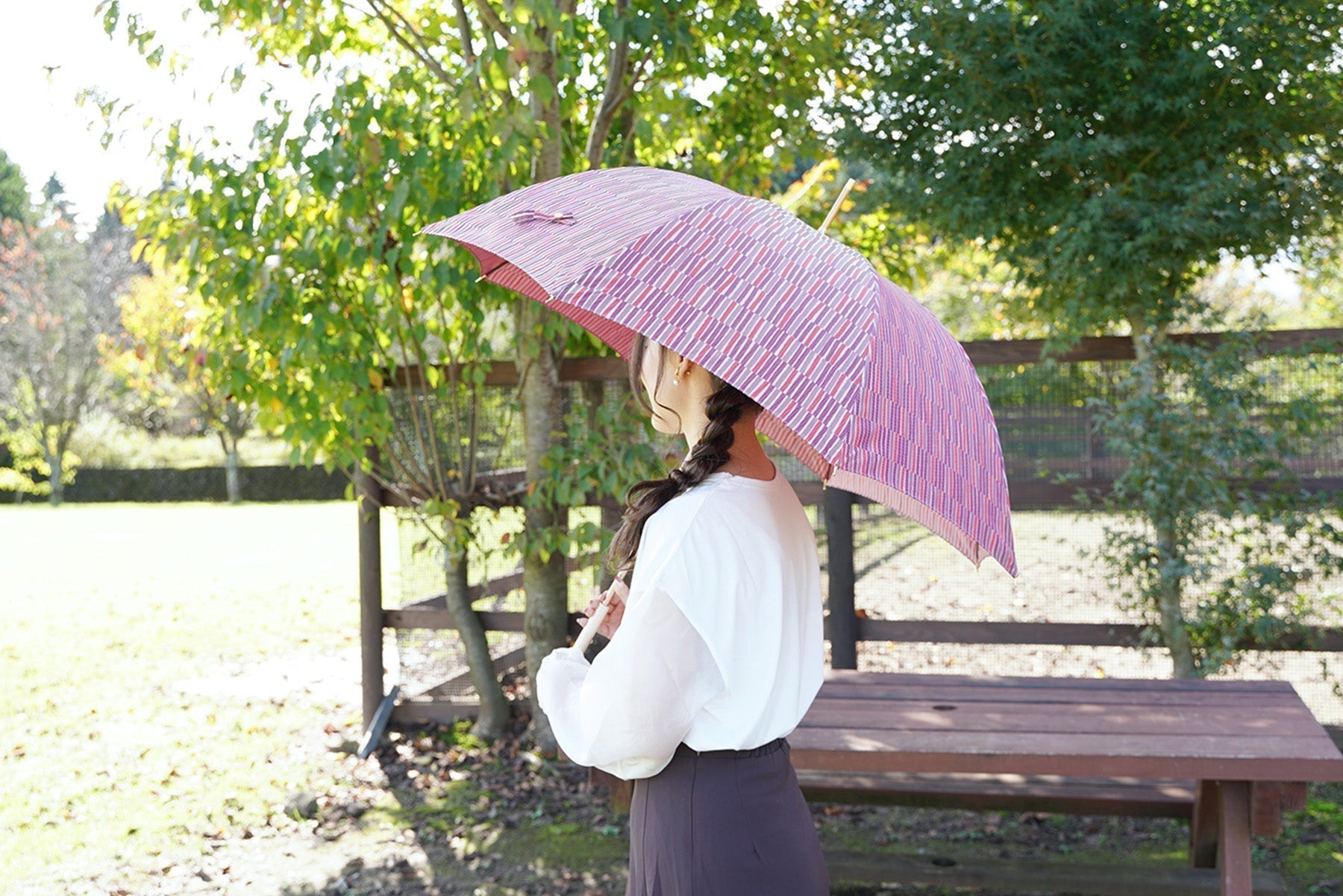 赤い晴雨兼用傘を差す女性