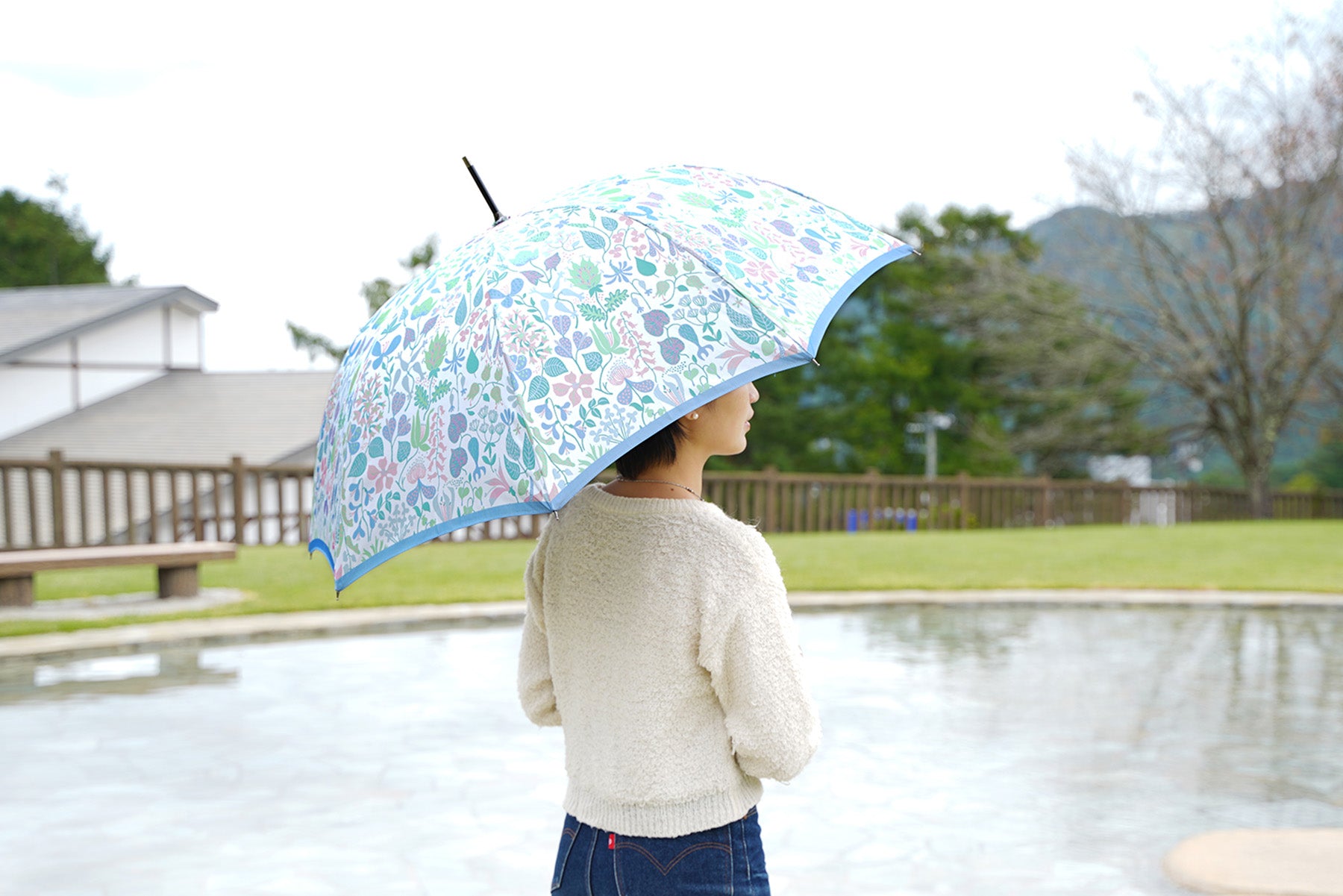 植物柄の婦人傘を差す様子