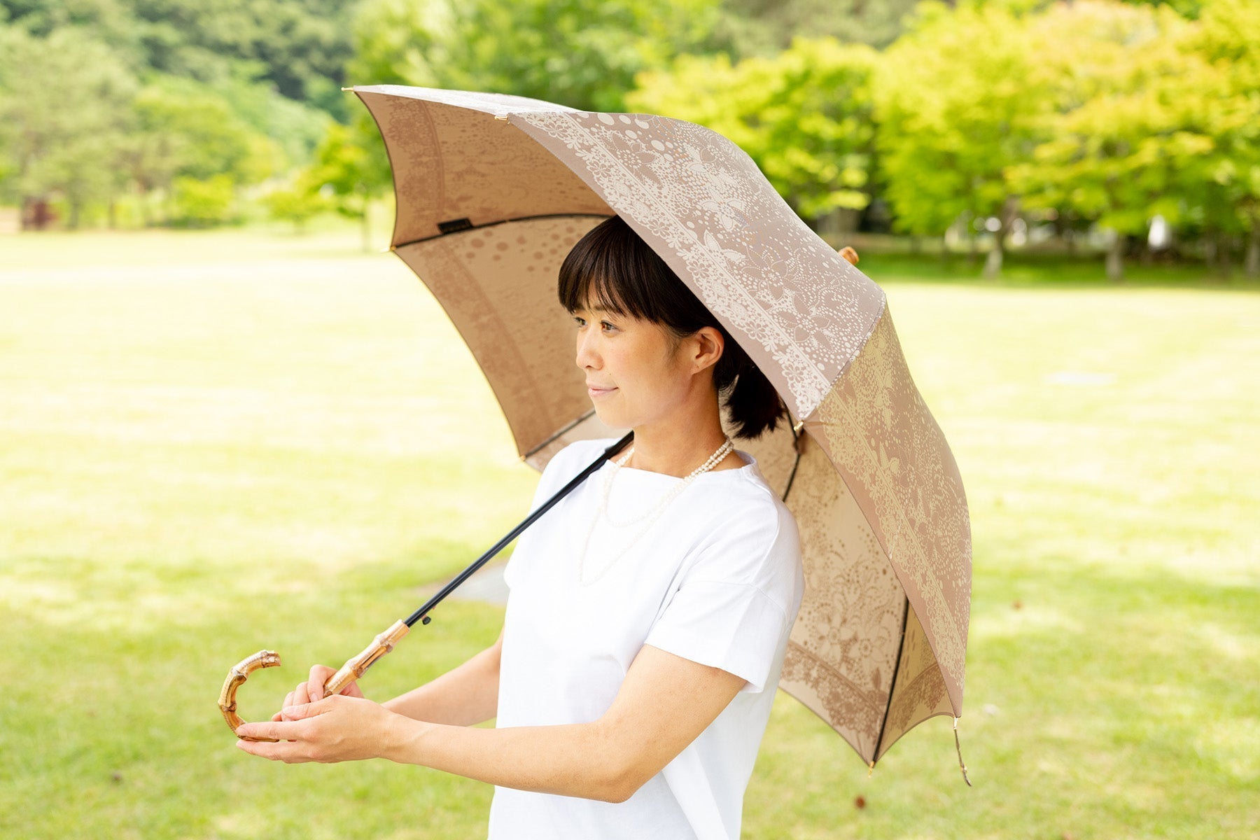 ブラウンのレディース傘を差す女性
