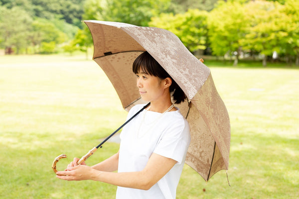 ブラウンのレディース傘を差す女性