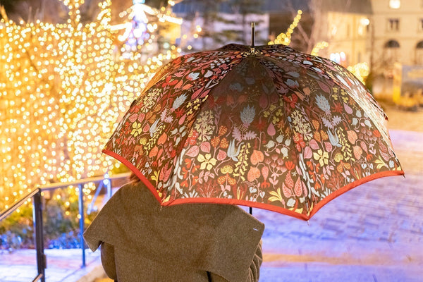 赤色のレディース長傘を差す女性