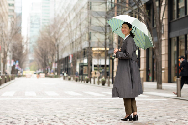オフィス街で傘をさす女性