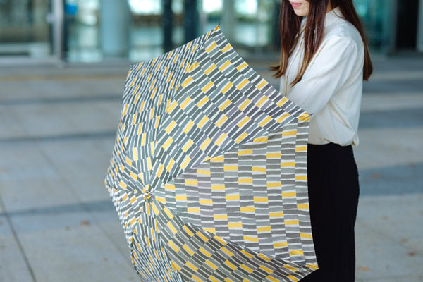 北欧風デザインの折りたたみ傘を持つ女性