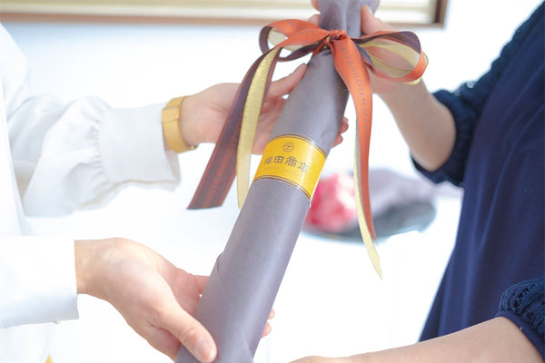 ラッピングされた傘を手渡す様子