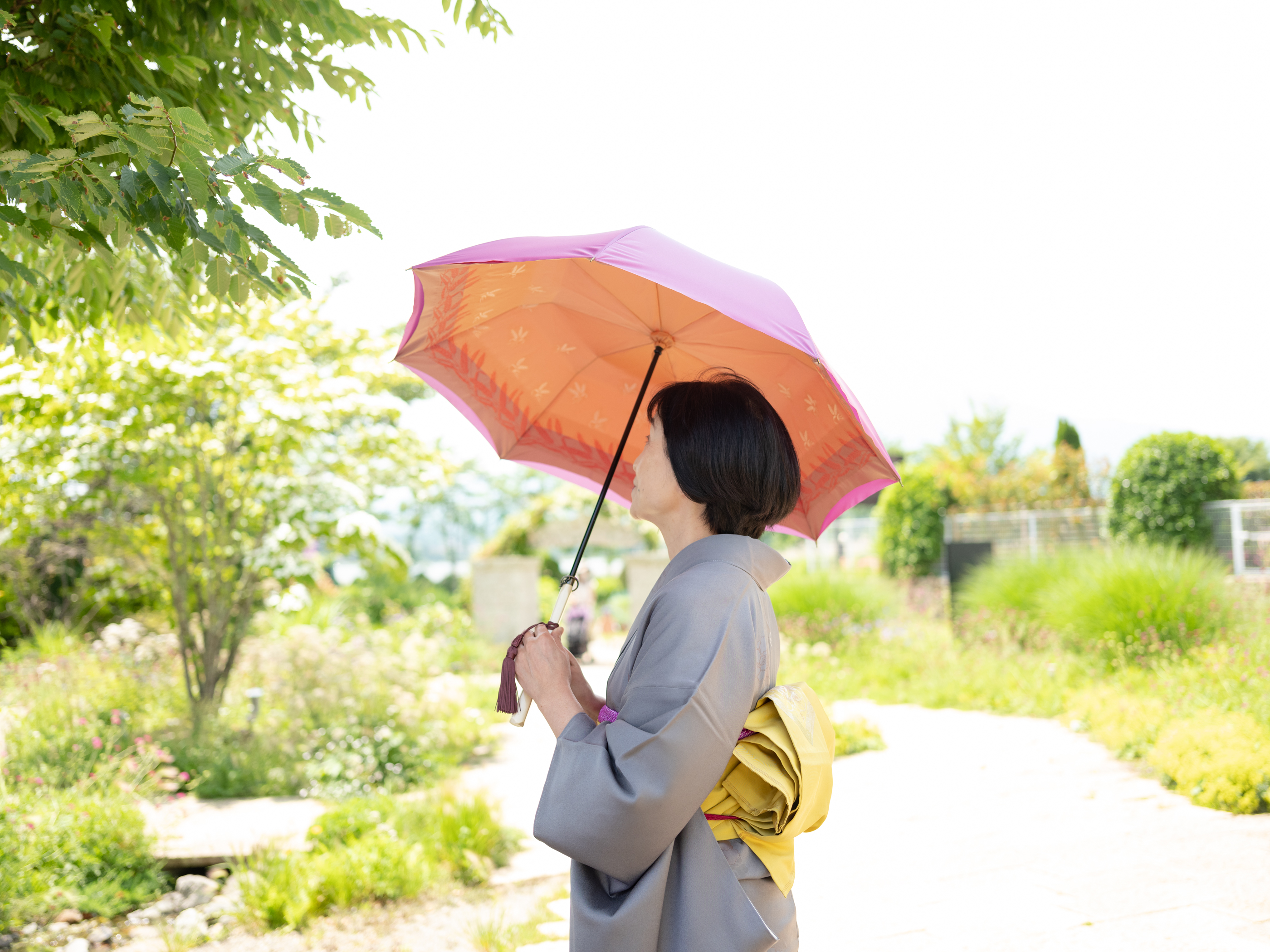 紫とオレンジ色の高級傘を差す女性