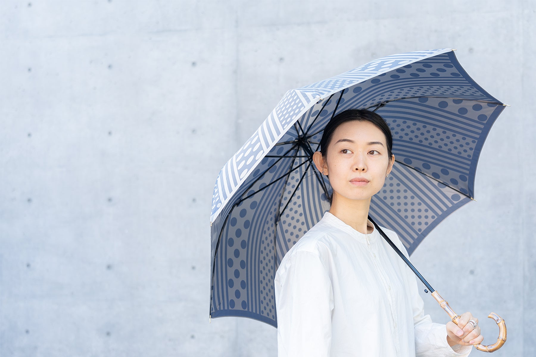 ブルーのレディース長傘を差す女性